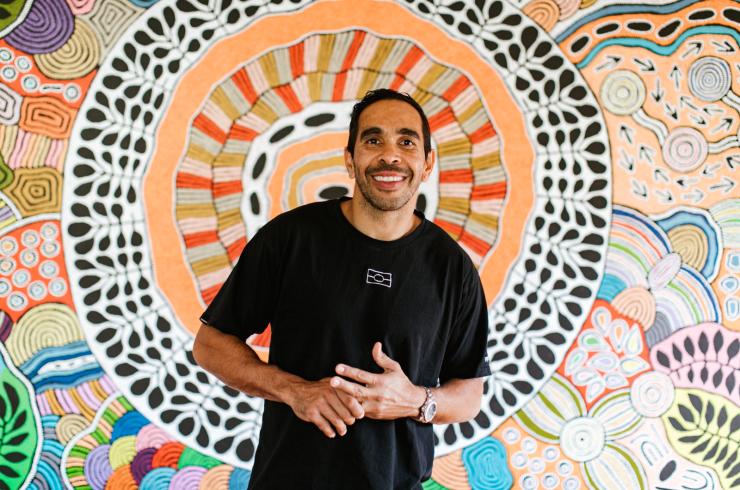 AFL player Eddie Betts standing in front of a decorative wall